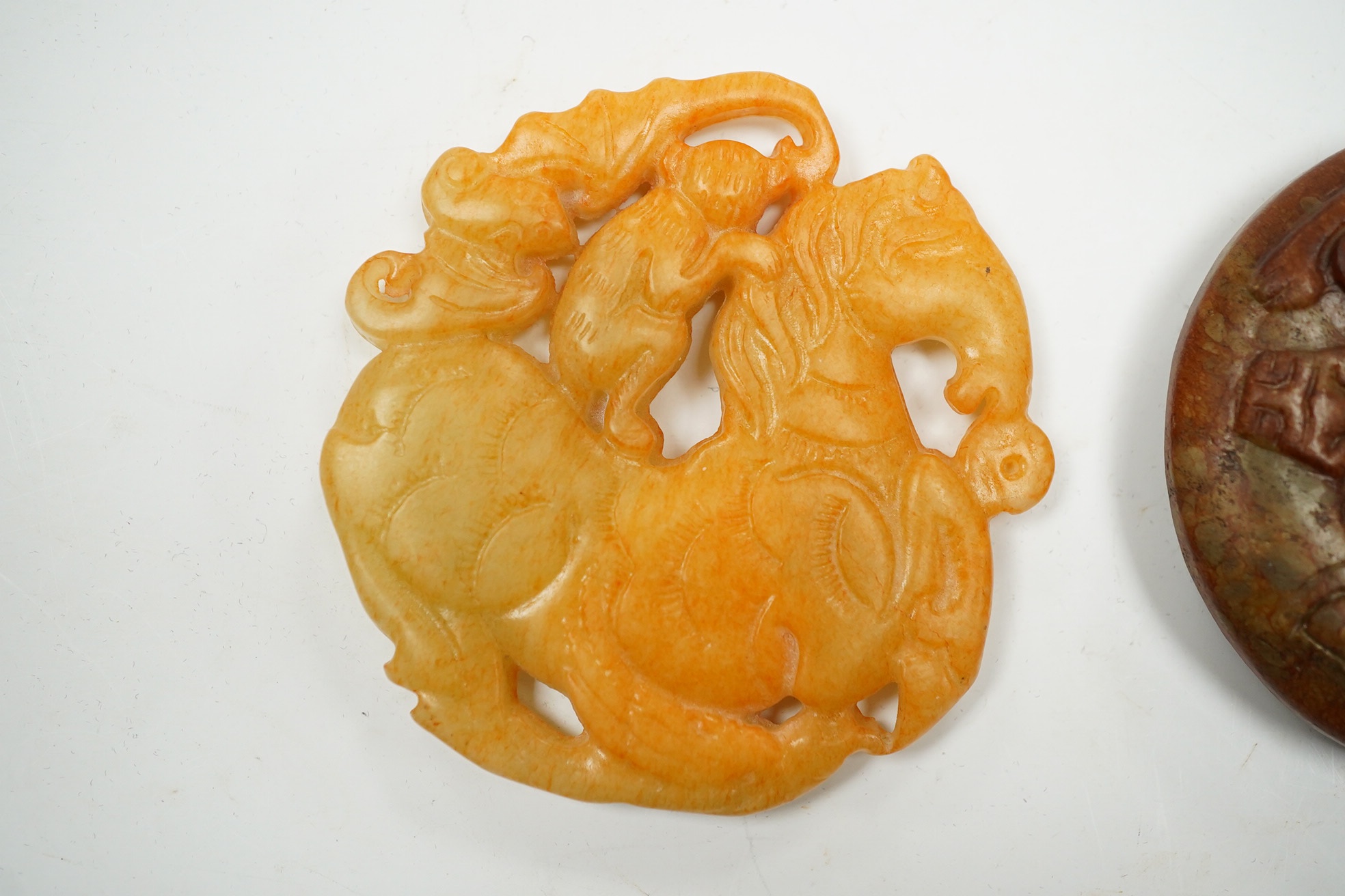 A Chinese russet and green jade bi disc and another plaque, largest 7cm diameter. Condition - good